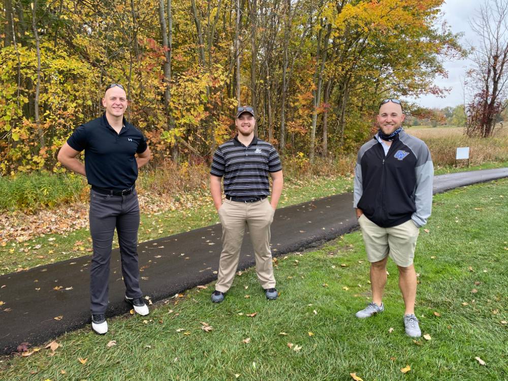 Three alumni by golf course